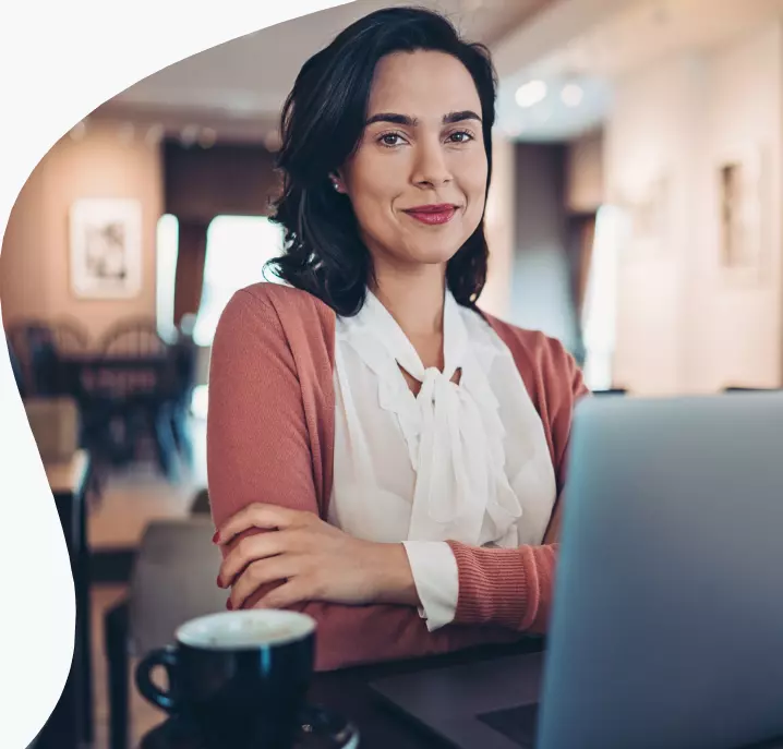Uma mulher sentada em frente ao seu notebook.